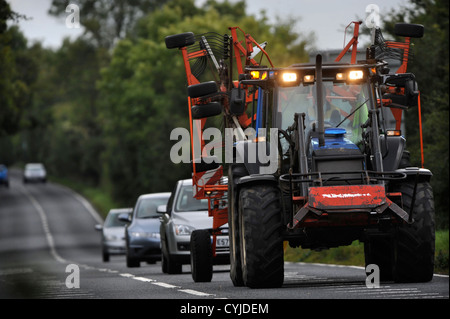Cars stuck behind a tractor on a road in Gloucestershire UK Stock Photo