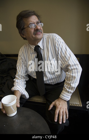 65 year old man having a cup of coffee at a cafe in midtown Manhattan. Stock Photo