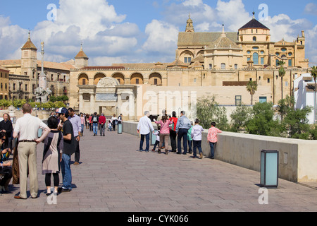 Tourists and local people on the Roman Bridge and Mezquita Cathedral (Great Mosque) in Cordoba, Spain, Andalusia region Stock Photo
