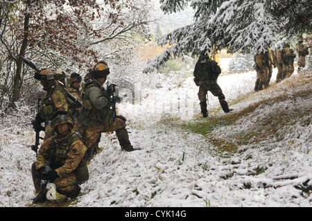 Italian soldiers from the 183rd Airborne Regiment pause in snow covered woodlands during a decisive action training environment Stock Photo