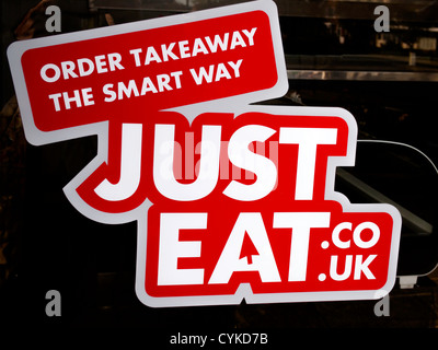 Sign for JustEat. co.uk in a small Fish and Chip Shop window website for customers to order takeaway food by Internet Stock Photo