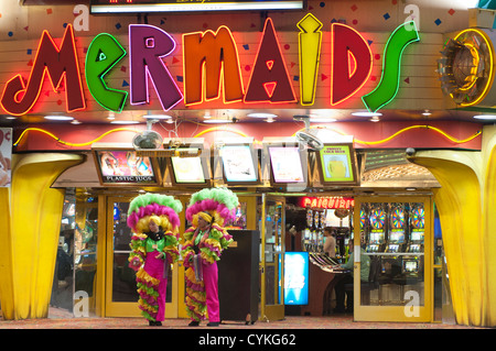 Showgirls in feathers outside Mermaids casino, nighttime at the Fremont Street Experience neon lights Las Vegas, Nevada, USA. Stock Photo