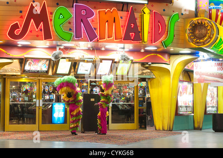 Showgirls in feathers outside Mermaids casino, nighttime at the Fremont Street Experience neon lights Las Vegas, Nevada, USA. Stock Photo