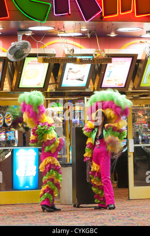 Showgirls in feathers outside Mermaids casino, nighttime at the Fremont Street Experience neon lights Las Vegas, Nevada, USA. Stock Photo