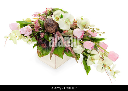 abstract composition from orchids, tulips,coconut, rocks and vines arrangement centerpiece in vase isolated on white background Stock Photo