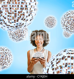 African American woman using cell phone with images floating above Stock Photo