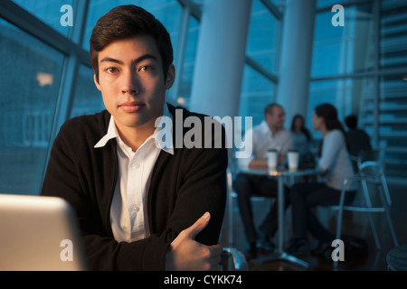 Mixed race businessman using laptop in cafe Stock Photo