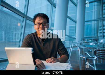 Asian businessman working with digital tablet in cafe Stock Photo