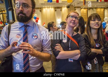 Nov. 7, 2012 - Bangkok, Thailand - COLIN CHENEY, left, MARY CONGER and NITHIDA LEEDHIRAKUL watch as US election results are posted at the US Embassy's election watch party in Bangkok. They all supported President Obama's reelection. US President Barack Obama won a second term Tuesday when he defeated Republican Mitt Romney. Preliminary tallies gave the President more than 300 electoral votes, well over the 270 needed to win. The election in the United States was closely watched in Thailand, which historically has very close ties with the United States. The American Embassy in Bangkok sponsored Stock Photo