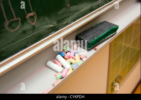 Pieces of chalk and a blackboard in the classroom of a school Stock Photo