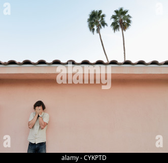 Man covering his face outdoors