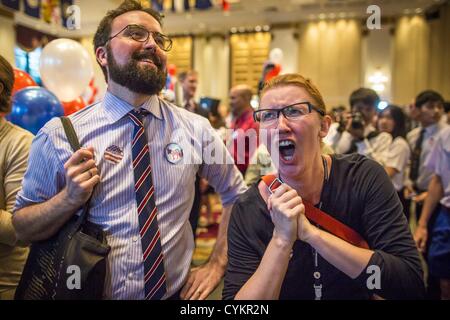 Nov. 7, 2012 - Bangkok, Thailand - COLIN CHENEY, left, and MARY CONGER watch as US election results are posted at the US Embassy's election watch party in Bangkok. They both supported President Obama's reelection. US President Barack Obama won a second term Tuesday when he defeated Republican Mitt Romney. Preliminary tallies gave the President more than 300 electoral votes, well over the 270 needed to win. The election in the United States was closely watched in Thailand, which historically has very close ties with the United States. The American Embassy in Bangkok sponsored an election watchi Stock Photo