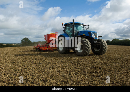 Tractor working in crop field Stock Photo