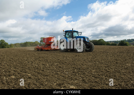 Tractor working in crop field Stock Photo