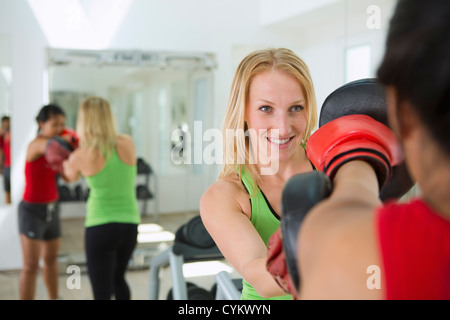 Trainer working with boxer in gym Stock Photo