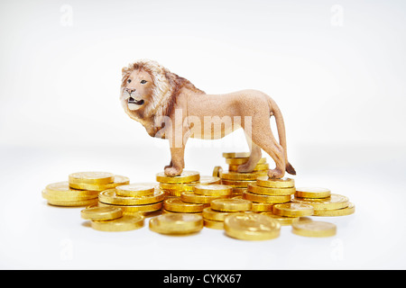Toy lion on stacks of gold coins Stock Photo