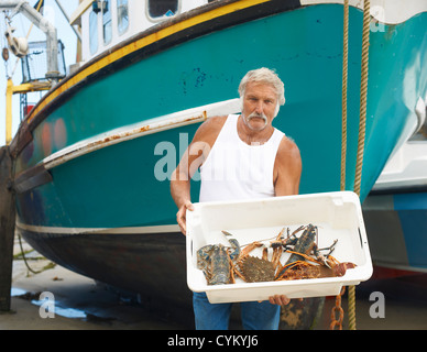 Fisherman holding catch on boat Stock Photo