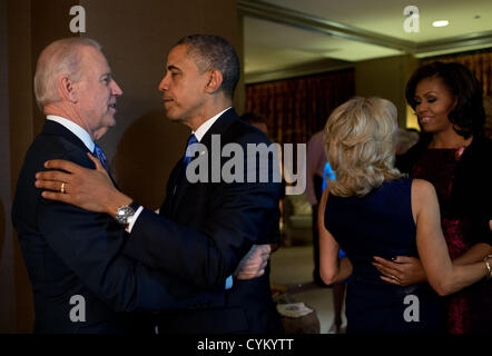 US President Barack Obama and First Lady Michelle Obama embrace Vice President Joe Biden and Dr. Jill Biden moments after the television networks called the election in their favor while watching election returns at the Fairmont Chicago Millennium Park November 6, 2012 in Chicago, IL. Stock Photo