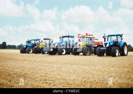 Tractors parked in tilled crop field Stock Photo