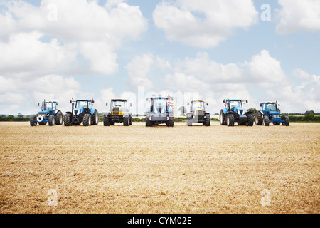 Tractor harvesting grains in crop field Stock Photo