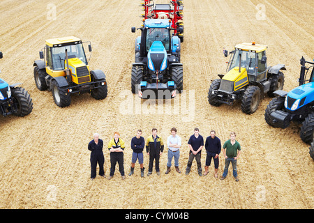 Farmers with tractors in crop field Stock Photo