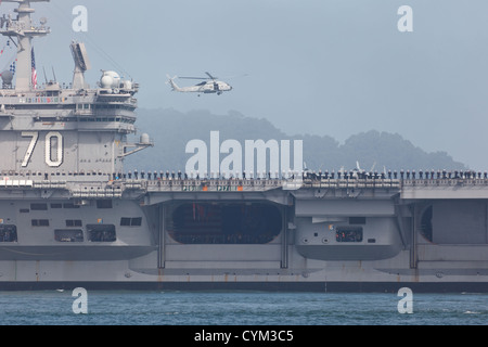 Detail of the flight deck of US NAVY Aircraft carrier USS Carl Vinson and hovering helicopter during Fleet Week in fog SF Bay Stock Photo