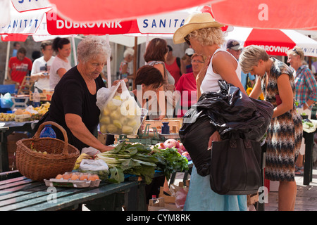 Older woman, market stall holder and shoppers in Dubrovnik city market. Croatia Stock Photo