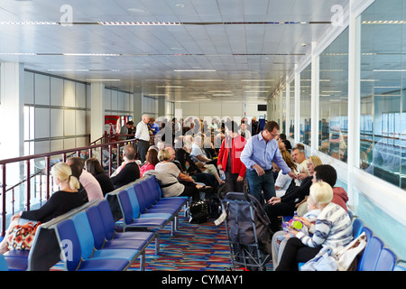 Passengers wait in a gate holding area at Gatwick Airport, London Stock Photo