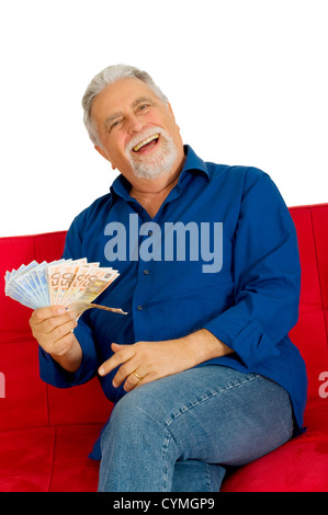 elderly man on the couch with money in hand Stock Photo