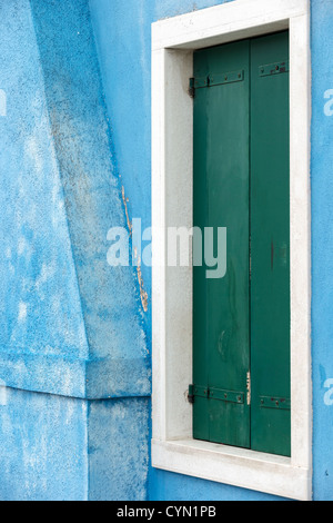 Detail of a house painted sky-blue, with a white window and green shutters in Burano, Italy Stock Photo