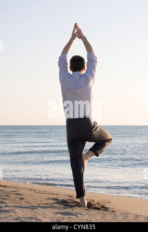 Businessman doing yoga Stock Photo