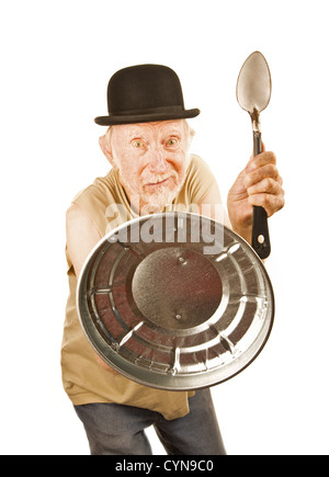 Senior in bowler hat defending himself with spoon and can lid Stock Photo