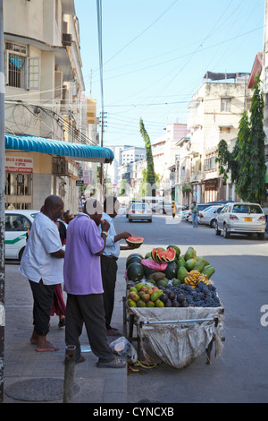 Men eating fruit in street, Dar Es Salaam, Tanzania Stock Photo