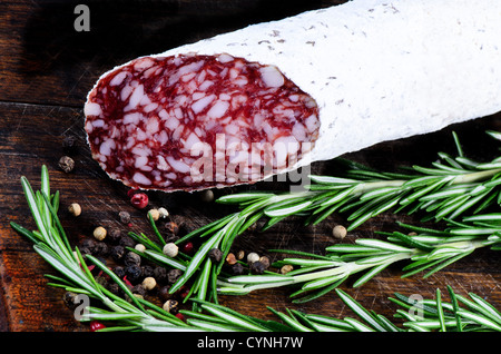 Salami and peper corns with rosemary on cutting board Stock Photo