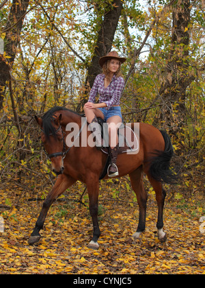 Cowgirl riding a bay horse Stock Photo