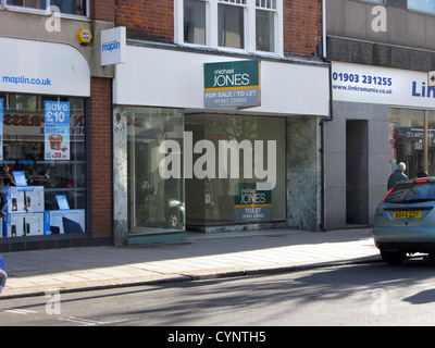 Unoccupied empty retail store in Worthing West Sussex UK with a to let for sale board up Stock Photo