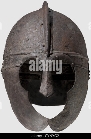 A late Roman iron helmet,circa 4th/5th century A.D.Formed of several sections hinged and riveted in place,the domed cap with a brow band off set by horizontal ribs,the two halves of the cap joined to a central ridge by rivets,the nose-guard and ornamental arching brows riveted to the brow band,the cheek-pieces flanged toward the neck and hinged to the brow band,each perforated below the chin,the neck-guard with an everted hemispherical flange hinged to the back of the brow band Height 27.5 cm,Weight 1426 grams.Provenance: American Private Collection,,Additional-Rights-Clearences-Not Available Stock Photo