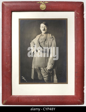 Adolf Hitler - Andreas Hofmann, A framed dedication photograph 'Dem lieben Vater Hofmann - dem Ältesten PG. der Bewegung herzlichst zugeeignet - Adolf Hitler - München, Weihnachten 1933' (For the dear Father Hofmann - the oldest party comrade of the movement kindest dedicated - Adolf Hitler - Munich, Christmas 1933). Photograph by H. Hoffmann, Hitler in his party uniform with coat. On passepartout, behind glass and in a ruby-coloured leather frame with a superimposed early-version national eagle made from brass on top. The reverse side also in ruby-coloured lea, Stock Photo