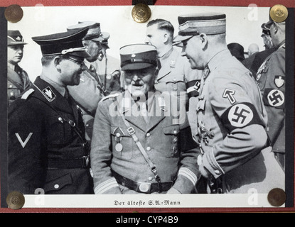 Adolf Hitler - Andreas Hofmann,A framed dedication photograph 'Dem lieben Vater Hofmann - dem Ältesten PG.der Bewegung herzlichst zugeeignet - Adolf Hitler - München,Weihnachten 1933'(For the dear Father Hofmann - the oldest party comrade of the movement kindest dedicated - Adolf Hitler - Munich,Christmas 1933).Photograph by H.Hoffmann,Hitler in his party uniform with coat.On passepartout,behind glass and in a ruby-coloured leather frame with a superimposed early-version national eagle made from brass on top.The reverse side also in ruby-coloured lea,Additional-Rights-Clearences-Not Available Stock Photo