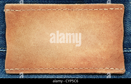 Blank leather jeans label sewed on a blue jeans. Can be used as background for your text. Stock Photo