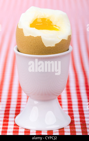 a breakfastt egg in a eggcup on red checked table cover Stock Photo