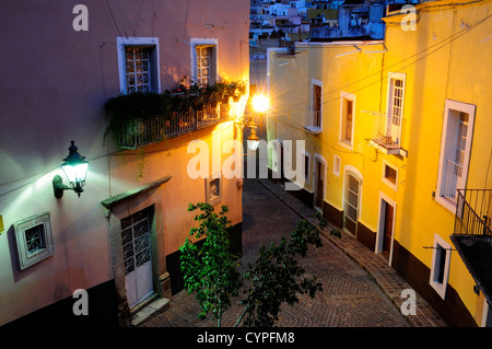 Mexico, Bajio, Guanajuato, Elevated view over street corner at night with painted building facades, balconies and street lights Stock Photo