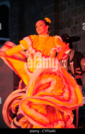 Mexico, Jalisco, Guadalajara, Plaza Tapatia, Female dancer in yellow flamenco style dress from Jalisco State at Carnival. Stock Photo