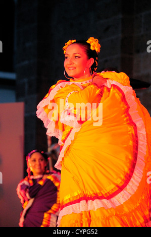 Mexico, Jalisco, Guadalajara, Plaza Tapatia, Female dancer in yellow flamenco style dress from Jalisco State at Carnival. Stock Photo