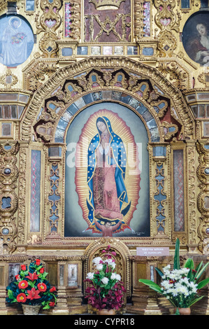 An ornately decorated altar with extensive gold lining depicting Our Lady of Guadalupe in the Iglesia de San Francisco (Church of San Francis). The church is most well known as the resting place and tomb of Santo Hermano Pedro de San Jose de Bethancourt (Saint Herman Pedro of Stain Joseph of Bethancourt), a locally revered figure from the 16th century who build a local hospital for the poor, amongst other things. Stock Photo