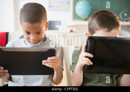 Students using digital tablets in classroom Stock Photo