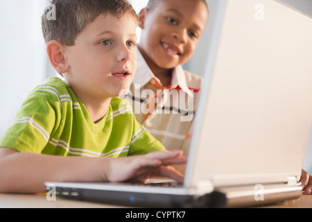 Boys using laptop together Stock Photo