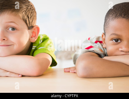 Bored boys leaning on table Stock Photo