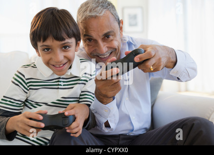 Hispanic grandfather and grandson playing video game Stock Photo