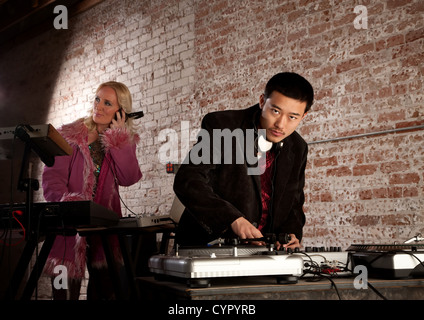 Cool DJ with turntable and blonde keyboardist Stock Photo